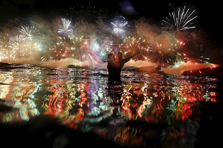 Fireworks going off over the Copacabana beach during New Year celebrations in Rio de Janeiro, Brazil, yesterday. Indonesians releasing sky lanterns to mark the new year during celebrations in Magelang, Central Java, yesterday. It's almost a tradition
