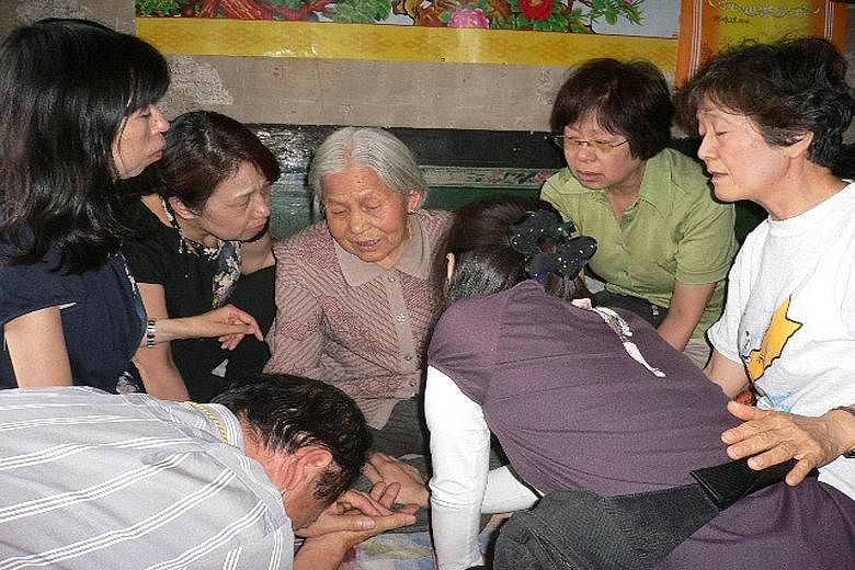 Members of the Japanese activist team apologising to former comfort woman Li Ai Lian (above) in August 2009. Left: Ms Tomoko Hasegawa (holding blue fan) with former comfort women Guo Mao Hai (pink fan) and Wang Er Hai (yellow fan) and other members o