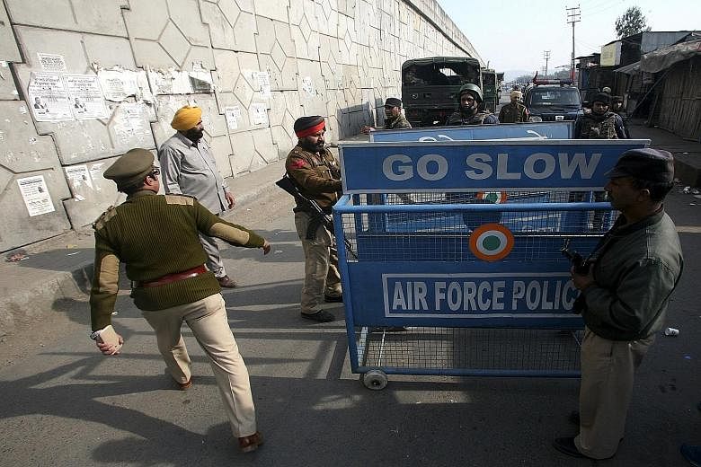 Indian security forces putting up a barricade outside the air force base in Pathankot, Punjab yesterday during an operation in which two more suspected insurgents were killed.