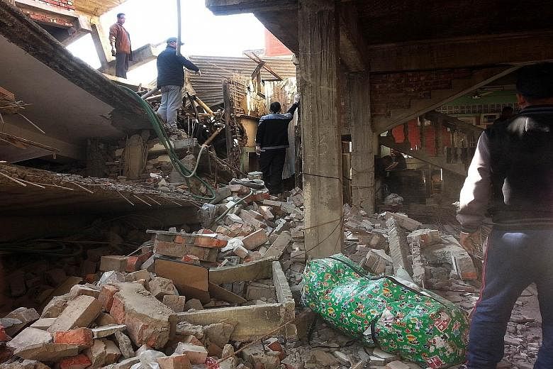 Residents inspecting the wreckage of a building in Imphal yesterday, after a 6.7-magnitude earthquake struck north-east India near the country's borders with Myanmar and Bangladesh.