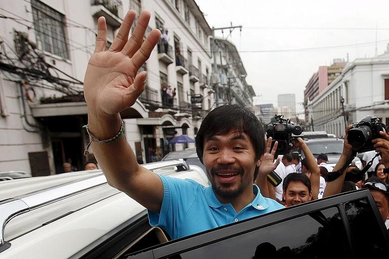 Manny Pacquiao waving after filing his certificate of candidacy for senator at the Commission on Elections in Manila for May's national polls.