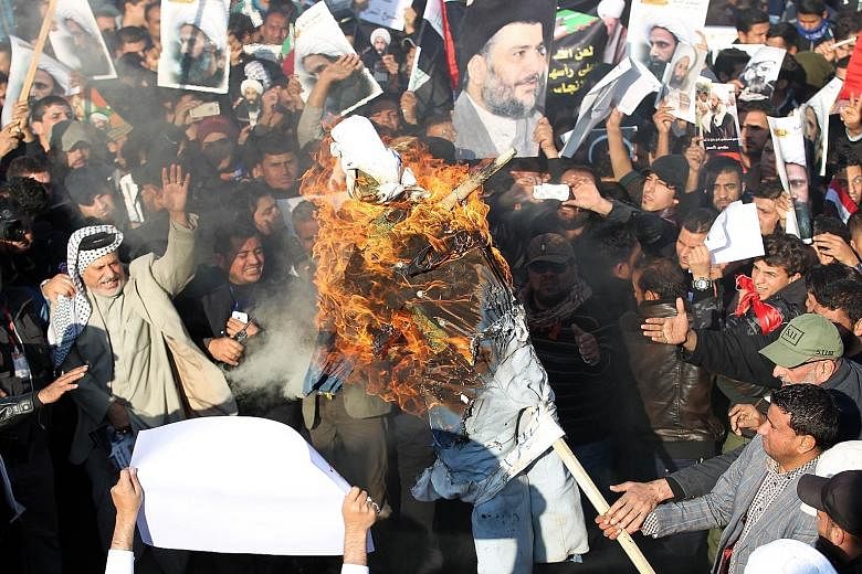 (Left) Iraqi protesters burning an effigy of a member of the Saudi ruling family during a demonstration in Baghdad on Monday against Saudi Arabia's execution of Shi'ite cleric Nimr al-Nimr. (Above) In Bahrain, a woman holding a poster of Nimr during 