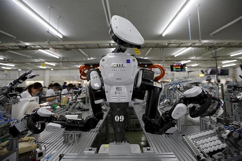 A robot on the assembly line of Japanese company Glory Ltd, which manufactures automatic change dispensers. Researchers say robots could fill the jobs done by half of Japan's workers within 20 years.