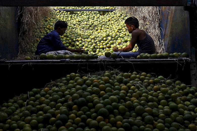 Workers sorting sweet limes at a fruit market in Kolkata, India. Emerging markets will continue to see weak growth, which will affect efforts to combat poverty, says the World Bank.