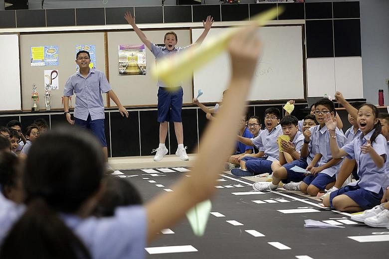Sec 1 students of Ping Yi Secondary Haritz Mohd Hasri (left) and Noah John Mitchell taking part in a fun competition to see who can make a paper aeroplane that will fly the farthest. This activity reflects the merged Ping Yi Secondary's design and ae