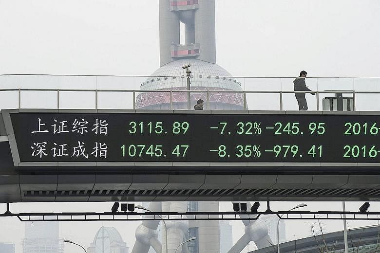 An electronic board showing the benchmark Shanghai and Shenzhen stock indexes on a pedestrian overpass in Shanghai, after the new circuit breaker mechanism suspended yesterday's stock trading.