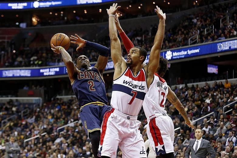 Cleveland Cavaliers guard Kyrie Irving shooting over Washington Wizards guard Ramon Sessions (centre) and forward Kelly Oubre in the first quarter. Irving played his best game in months to score a season-high 32 points.