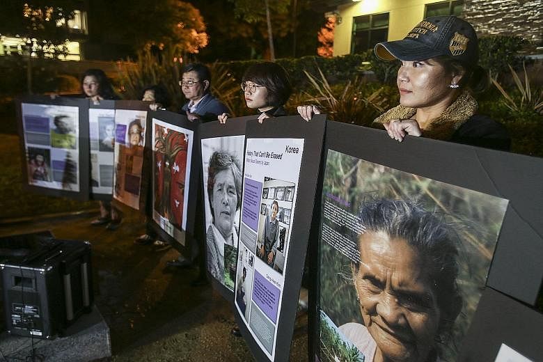 Portraits of former comfort women held up during a candlelight vigil in Glendale, California, on Tuesday, in remembrance and support of the victims of Japanese wartime sexual slavery.
