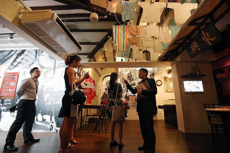 Mr Razeen Chan (extreme right), director for Research, Training and Consultancy at Singapore History Consultants, showing members of the media the gallery illustrating Chinatown in the 1960s.