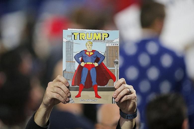 A supporter holding up The Trump Coloring Book at a campaign rally for US Republican presidential candidate Donald Trump. Mr Trump, 69, has never hesitated to offer himself as the incarnation of the American Dream.