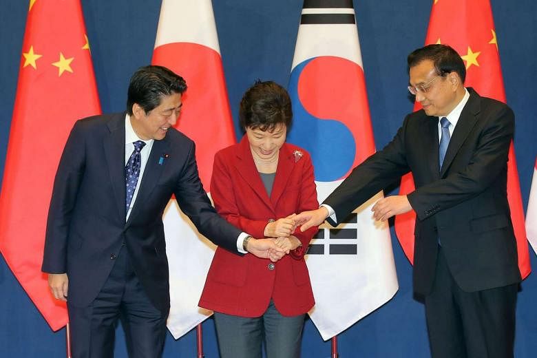 (From far left) Japanese Prime Minister Shinzo Abe, South Korean President Park Geun Hye and Chinese Premier Li Keqiang at a photo session ahead of a trilateral leadership summit in Seoul on Nov 1. The leaders of the three countries held their first summi