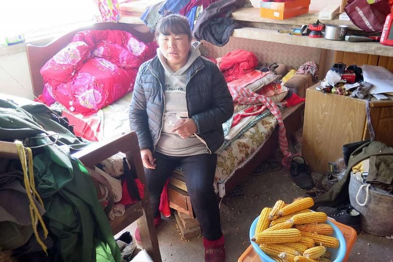Madam Zhang (above) in the cluttered bedroom of her squalid home, which also has a sparsely furnished living area, in the remote Aihetan village in Hebei province. Madam Zhang is gradually going blind as her family is too poor to take her to a doctor for 
