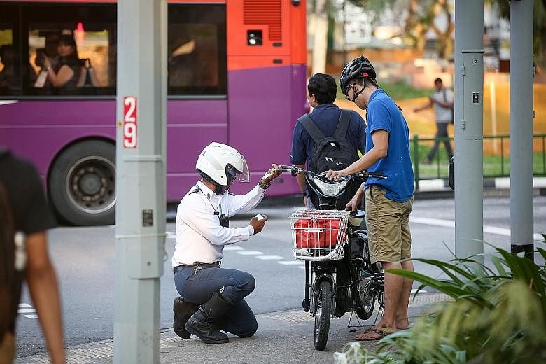 A user of an illegal motorised bicycle being pulled over by an enforcement officer from LTA in Boon Lay Drive last Wednesday. The two-wheeler was found to have a throttle, or start-up assistance feature, and had not been approved for use by the LTA.