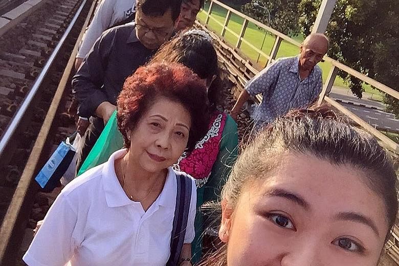 One train travelling in the direction of Marina South was stuck between Kranji and Marsiling stations yesterday. Commuters were forced to get off the train and walk towards Marsiling Station. Miss Chia (in front), who was one of them, took the MRT br