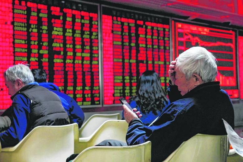 An investor checking his smartphone at a securities brokerage house in Beijing on Friday. Chinese shares had their worst start in two decades, with sharp price falls triggering so-called circuit breakers twice last week.