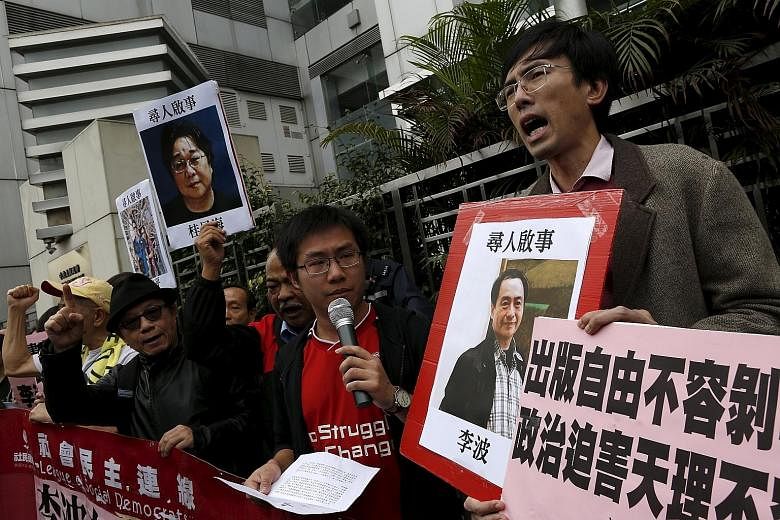 A pro-democracy demonstrator holds up a portrait of Mr Lee Bo (right) during a rally.