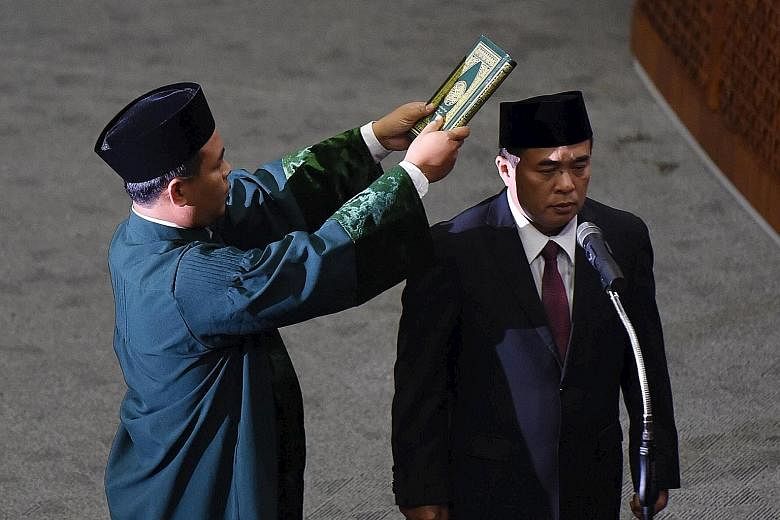 Mr Ade (right), a Golkar Party MP, being sworn in as the new Speaker of Indonesia's Parliament in Jakarta yesterday.