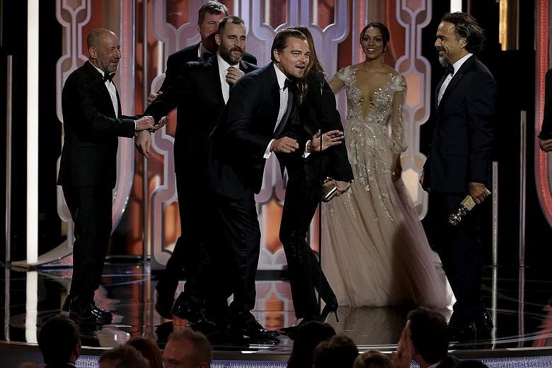 The Revenant star Leonardo DiCaprio (above, at the microphone) celebrating the film's win for Best Motion Picture, Drama with crew members including director Alejandro Gonzalez Inarritu (far right).