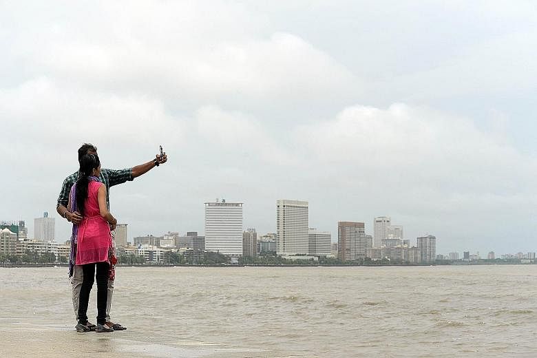 A couple taking a selfie on Marine Drive promenade in Mumbai. It is one of 16 places identified by police in the Indian city as dangerous selfie spots after a man drowned as he tried to save a girl and her two friends who had fallen into the sea whil