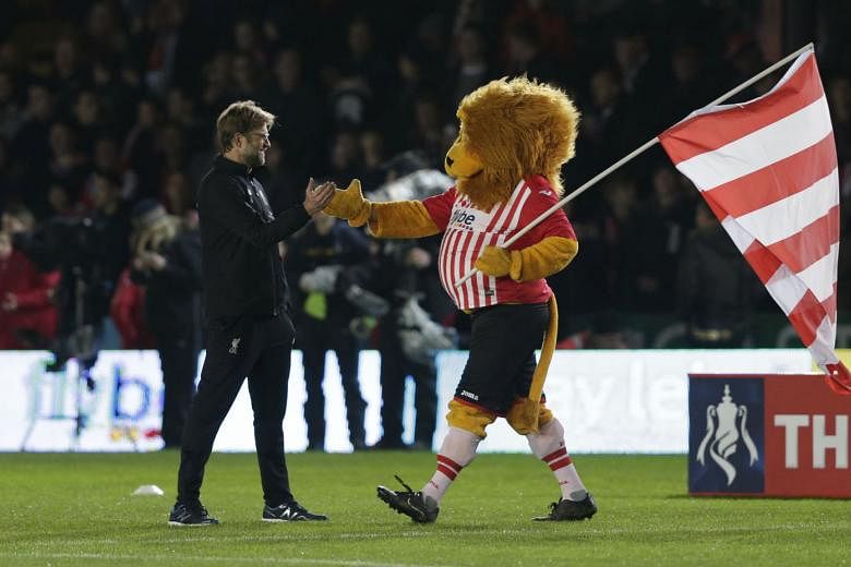 Liverpool manager Juergen Klopp getting friendly with Exeter City's mascot Grecian the Lion before the FA Cup third-round match at St James Park.