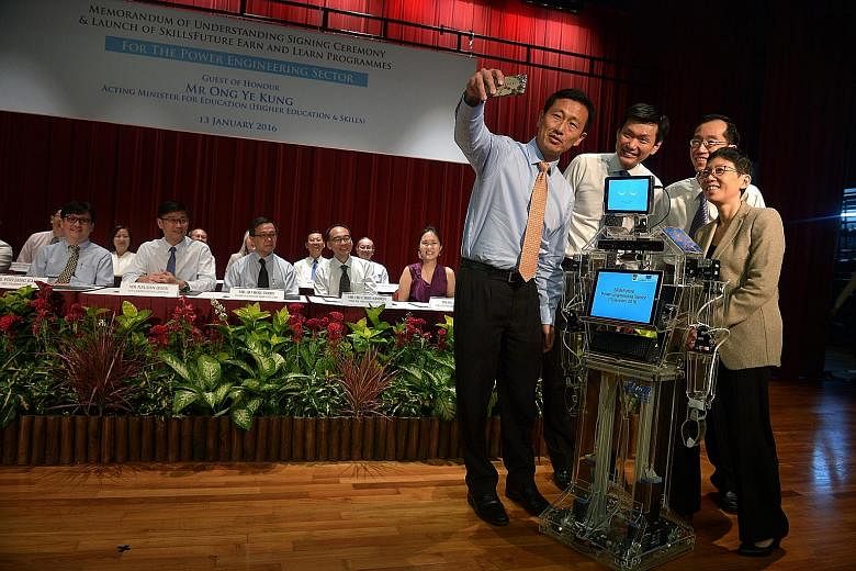 Taking a wefie with "Xuan" the robot, a student project, yesterday were (from left) Mr Ong Ye Kung, Ngee Ann Polytechnic principal Clarence Ti, Energy Market Authority chief executive Ng Wai Choong and group director of WDA training partners group Go