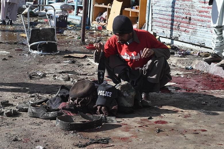 A volunteer collects the belongings of victims of the bomb blast. Policemen had gathered to accompany workers for a polio vaccination campaign in Quetta.