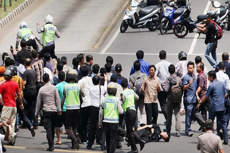 In a series of pictures taken by a Tempo photographer yesterday, at least one policeman was shown being gunned down by the two militants. The shooting took place at the intersection of two major roads in Jakarta's business district, where a crowd had