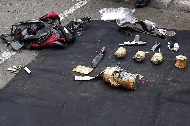 (Above) A police bomb squad member approaching the scene of an explosion following the terrorist attack in central Jakarta yesterday. (Right) Some of the weapons reportedly carried by the terrorists in the attack. Indonesian President Joko Widodo (ce