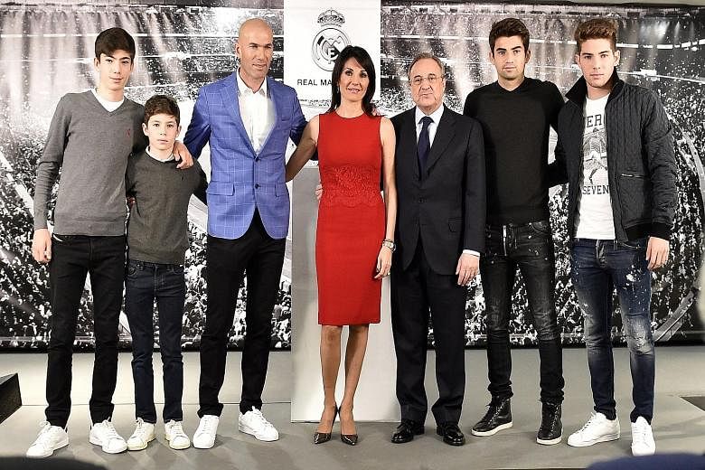 Zinedine Zidane (in blue) posing with his wife Veronique, their four sons and Real Madrid president Florentino Perez (in suit). The Zidane boys are among the youth players that the club signed, apparently breaching the rules on signing non-Spanish un