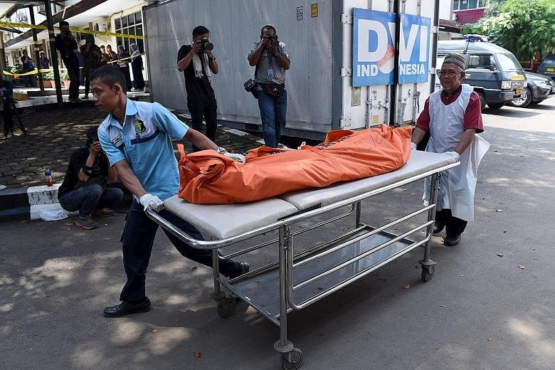 Hospital workers wheeling away the body of a person who died in Thursday's attack, at Kramat Jati Police hospital in Jakarta yesterday. The blasts and ensuing shoot-out in downtown Jakarta left seven dead, of whom five were the attackers.