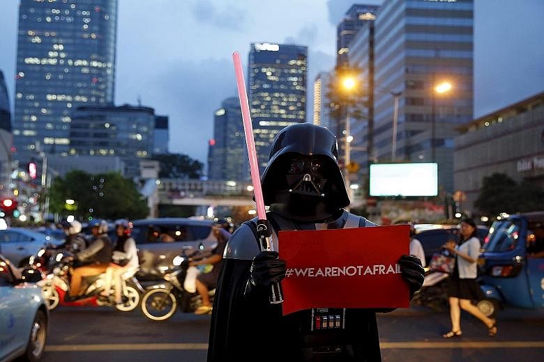 A man wearing a Darth Vader costume making a statement with his placard in Jalan M.H. Thamrin in downtown Jakarta yesterday, near the scene of Thursday's attack.
