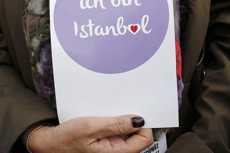 A woman expresses her sympathies with the phrase "I am Istanbul", in German. The 10 victims of the recent terror attack in Istanbul were all German tourists.