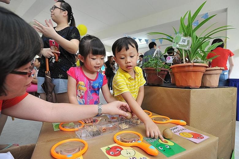Xara Sze (left, in pink) and Gabriel Tan (in yellow), both five, trying out a learning exercise at yesterday's carnival held at Block 415 Yishun Avenue 11, which is next to the Skool4Kidz Yishun Large Childcare Centre. The new two-storey, 2,000 sq m 