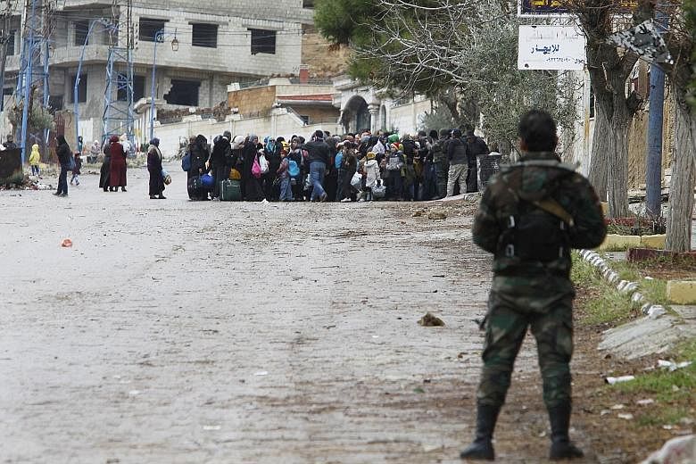 Syrian soldiers monitoring residents who said they had received permission from the government to leave Madaya after an aid convoy entered the besieged town last Thursday.