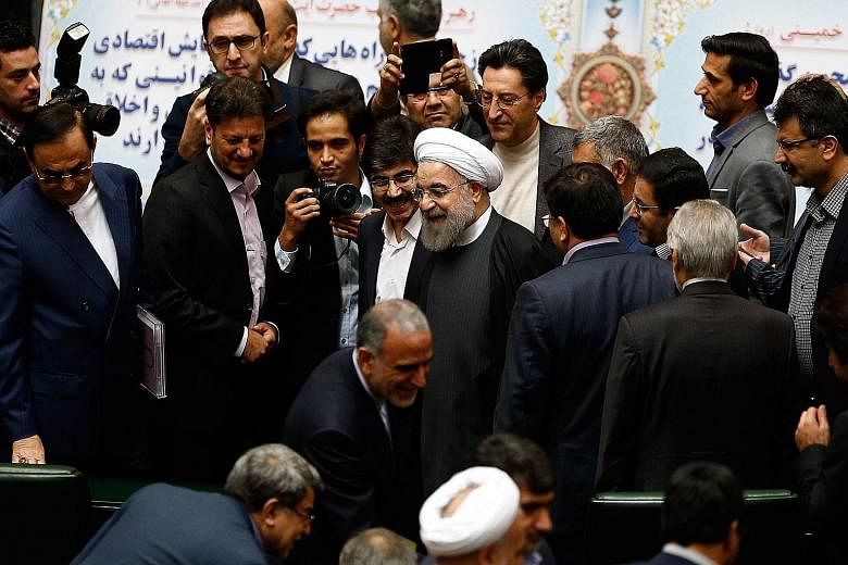 MPs congratulating Mr Rouhani (centre) yesterday during a parliamentary session on the Budget after some international sanctions against Iran were lifted.