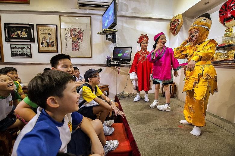 Primary 5 pupils from River Valley Primary School watching the Monkey God and other characters, played by schoolmates (from far left) Cayden Cheong, Chua Huiting and Sherwin Leow, in a Chinese opera. The event, to help pupils from selected schools le