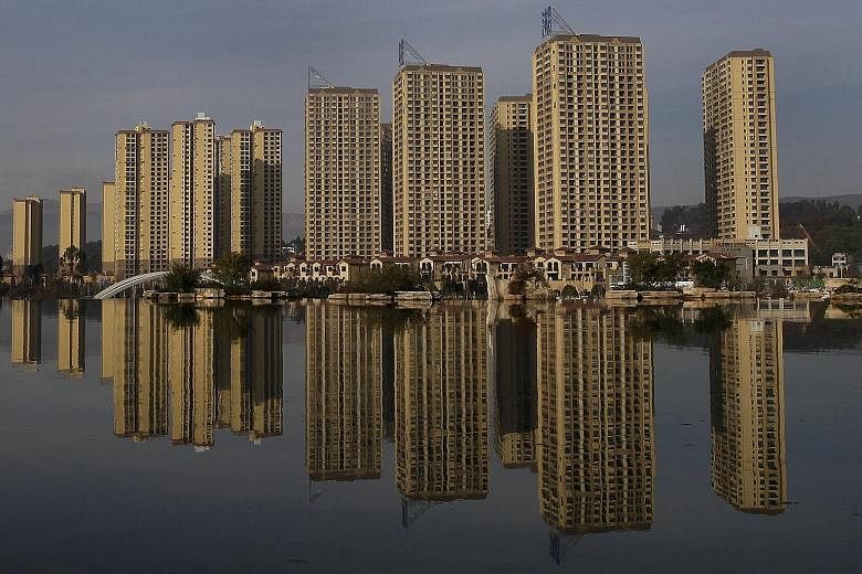Newly-constructed residential buildings in Yunnan province in China. As part of the country's easing measures, the central bank has reduced interest rates six times since November 2014, along with a cut in reserve requirements for all banks, helping 