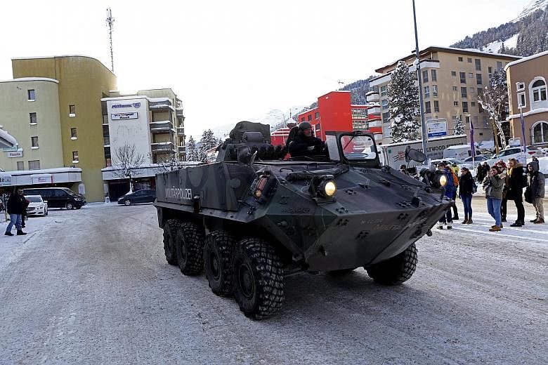 An armoured military police vehicle moving past the Davos Dorf railway station on Monday as Switzerland prepares to host leaders from around the world at the World Economic Forum.
