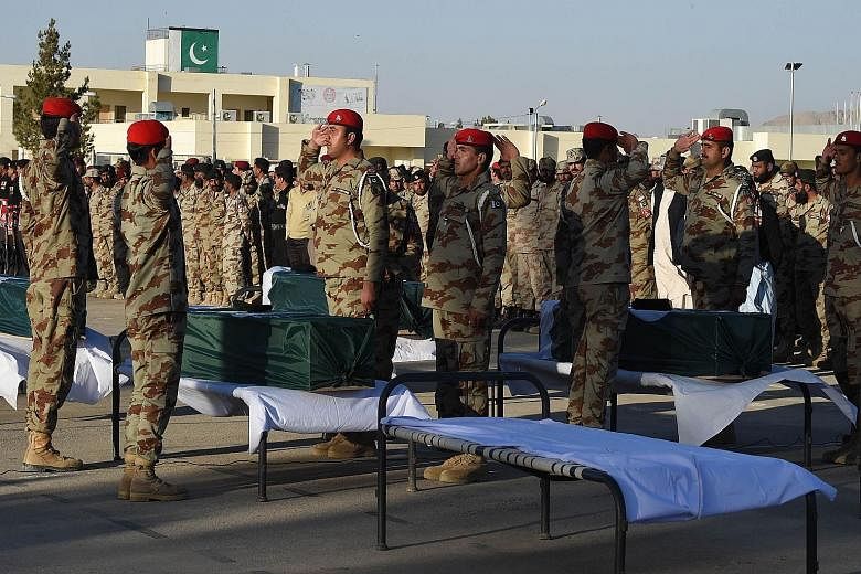 Pakistani paramilitary soldiers saluting the coffins of their colleagues during a funeral ceremony in the city of Quetta on Monday. At least six paramilitary soldiers were killed when their vehicle hit a roadside bomb in Pakistan's south-western prov