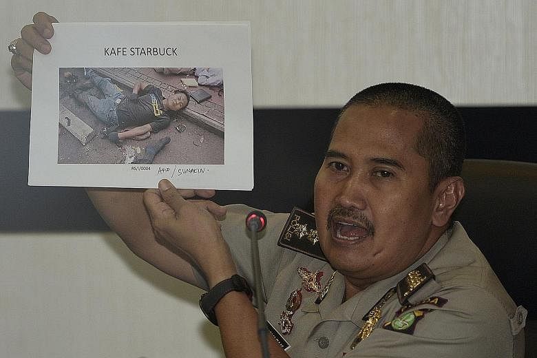 Jakarta police medical division chief officer Musyafak showing a photo of dead militant Sunakim (alias Afif), one of the four men who carried out last Thursday's attack in Jakarta. Police believe the alleged mastermind is an Indonesian fighting with 