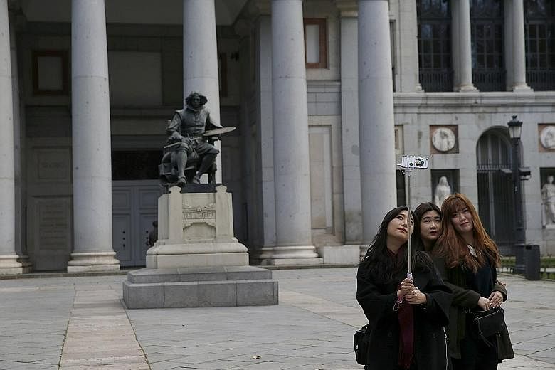 Tourists taking a wefie in front of a statue of Spanish painter Diego Velazquez outside the Prado Museum in Madrid. The number of international tourists rose by 4.4 per cent worldwide last year to hit a record 1.18 billion despite concerns over extre