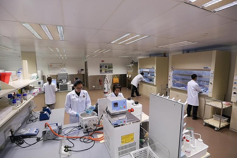 The ICA yesterday opened the doors of its $2.9 million chemistry laboratory to the media for the first time. Seen at work are officers from the ICA and the Ministry of Home Affairs' Office of the Chief Science and Technology Officer.