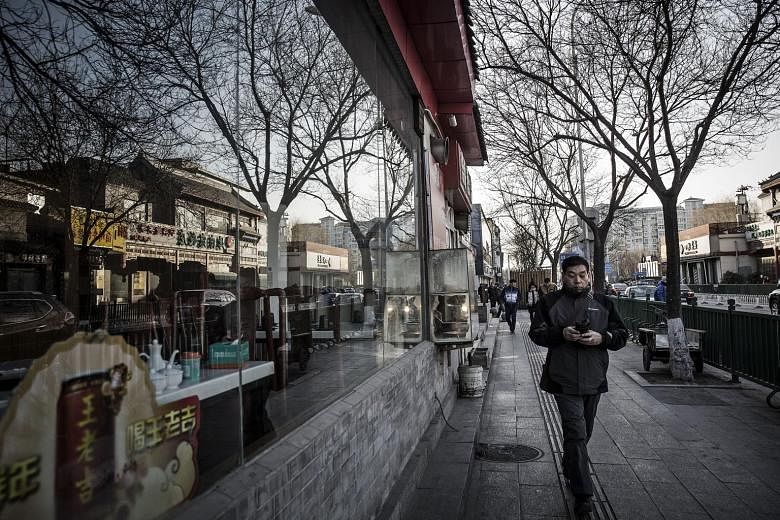 A pedestrian passes by a restaurant in Beijing. China accounted for the bulk of the net capital outflows last year, with about US$676 billion withdrawn from the world's second largest economy last year.