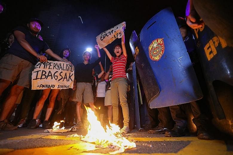 Students burning a mock American flag outside the US Embassy in Manila yesterday during a rally against the US-Philippine Enhanced Defence Cooperation Agreement. The pact allowing an increased presence of US military forces for training in the Philip