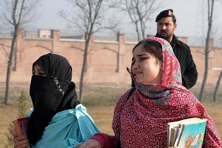 Students fleeing Bacha Khan University in Charsadda (above) following an attack by militants yesterday, while army soldiers rescue a victim (left).