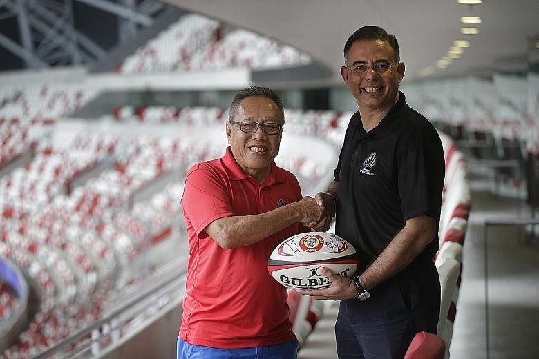 SRU president Low Teo Ping and Sports Hub CEO Manu Sawhney with the ball they had signed at the National Stadium. The cost-sharing venture could be a model for promoters staging their events at the venue.