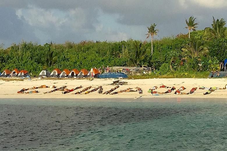 Filipinos forming the words "China out" on a Philippine-held island in the South China Sea on Dec 31. They were among 50 Filipinos who protested against China's claims over much of the sea.