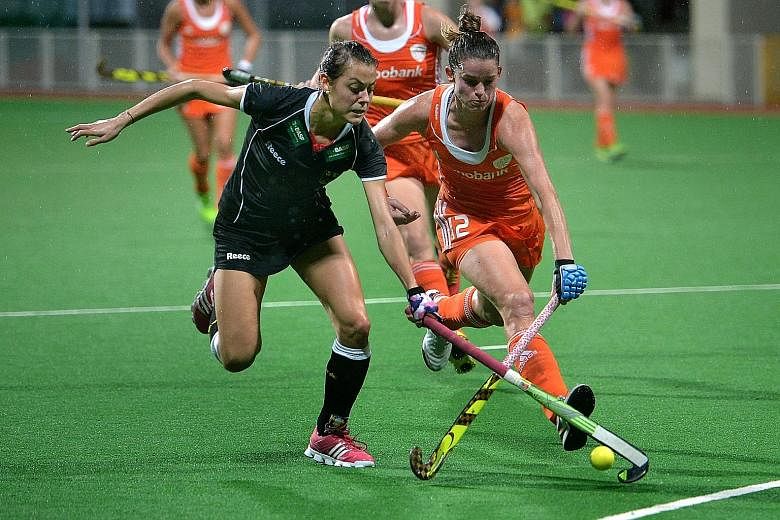 Lidewij Welten (right) jostles for the ball with German defender Selin Oruz in the Netherlands women's hockey team's 3-0 win at Sengkang Stadium last night on day five of The Project Group International Tri-Series. Welten scored the third goal during