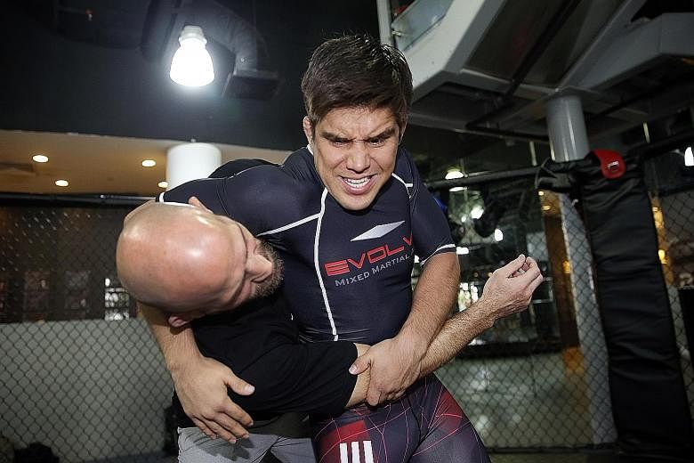 Henry Cejudo (right) grappling with Evolve MMA head coach Heath Sims. The 2008 Olympic 55kg freestyle wrestling champion is brushing up on Brazilian jiu-jitsu and muay thai in Singapore. He is confident of beating fellow American Demetrious Johnson, 