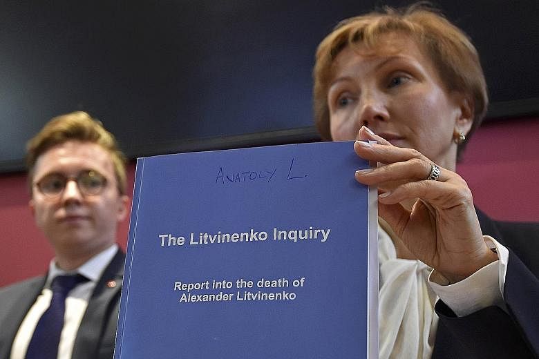 Ms Marina Litvinenko, widow of murdered former KGB agent Alexander Litvinenko, and her son, Anatoly, with a copy of the inquiry report on Thursday. Mr Litvinenko died of radiation poisoning in 2006 after drinking tea laced with radioactive polonium a